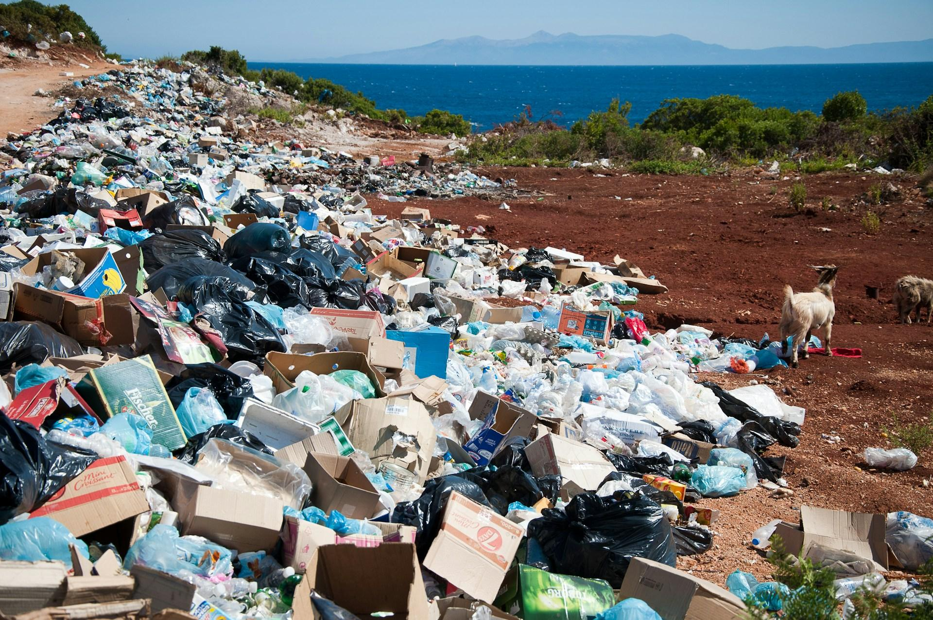 Packaging-waste-including-cardboard-boxes-and-plastic-bags-piled-at-an-open-dump-site
